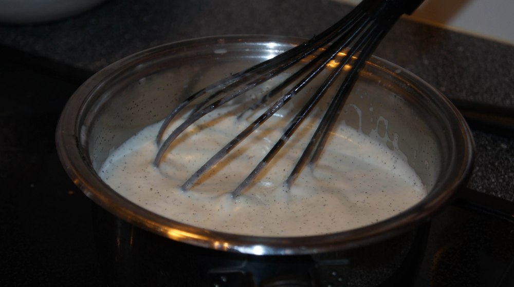 Kok opp fløte og frøene fra vaniljestangen. Trekk kjelen av plata, klem vannet ut av gelatinen og tilsett i den varme fløten. Rør rundt til alt er oppløst. Ikke la koke etter at gelatinen er hatt i.